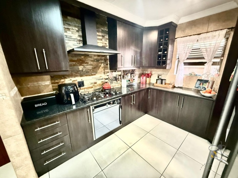 Secunda Central, double-storey home, 3 bedroom house for sale, indoor braai, granite countertops, gas stove, JoJo tank, high security, CCTV, wide staircase, modern living.